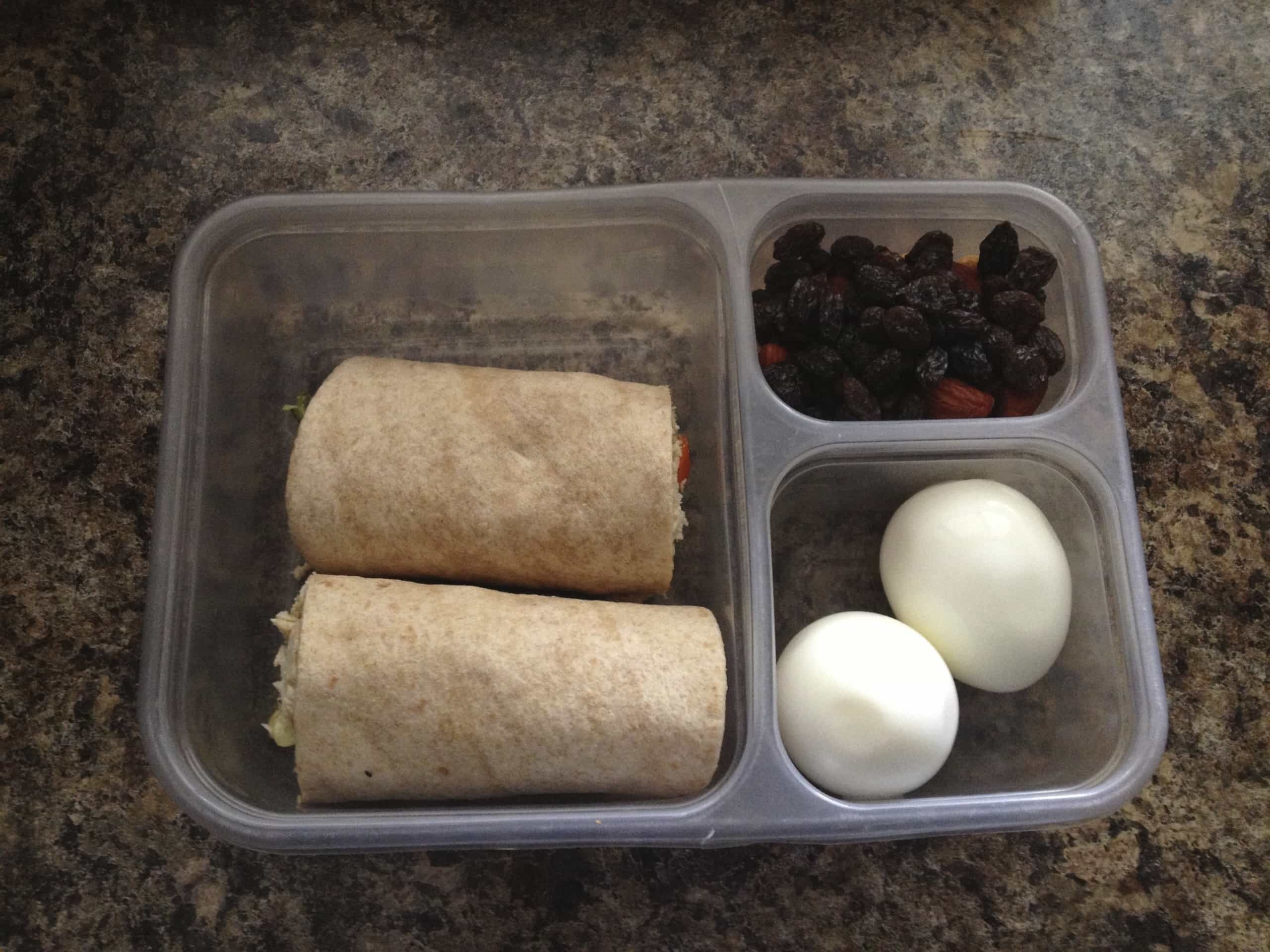 Brown bag lunch of wraps, dried fruit, and hard boiled eggs. 