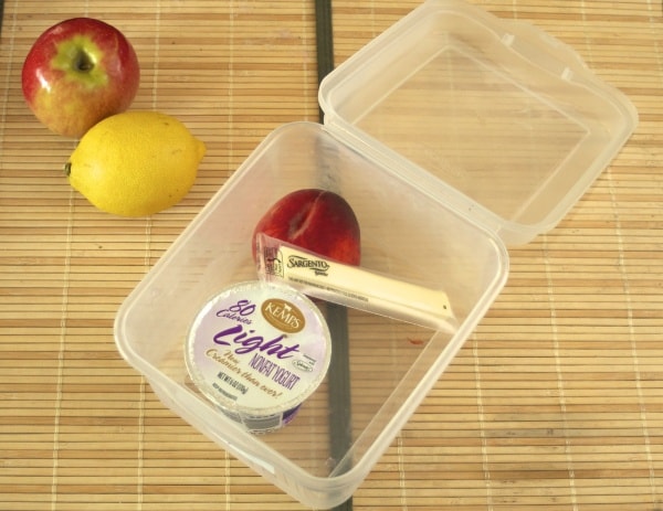 yogurt and string cheese in a storage container