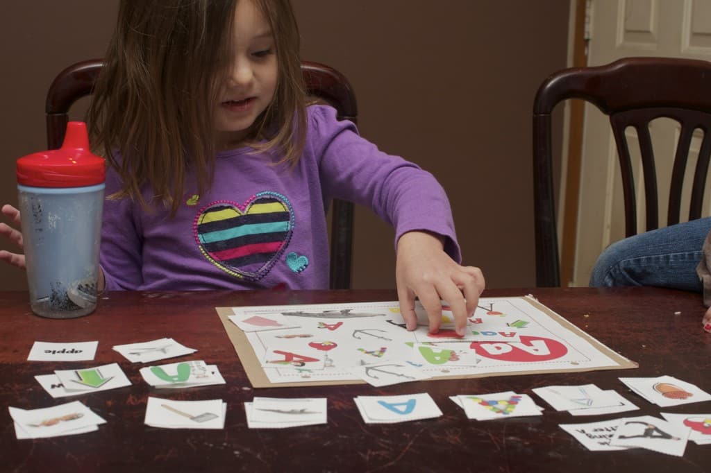 Preschooler matching up words that start with the letter A.