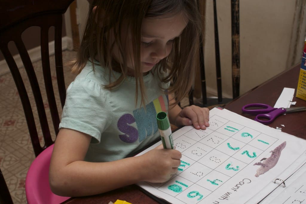 Little girl tracing numbers. 