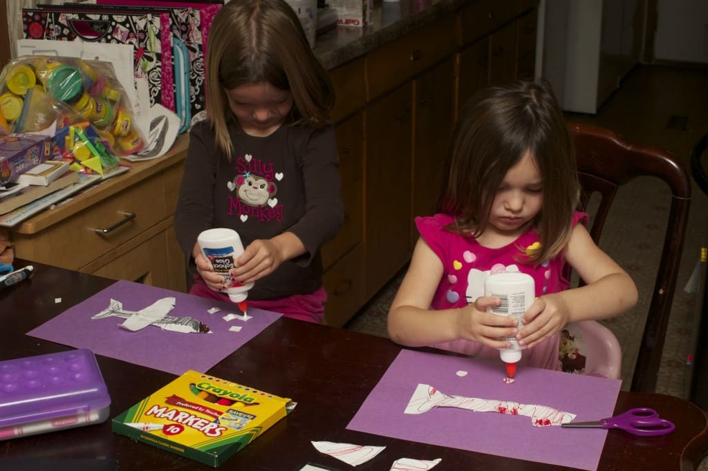 sisters crafting paper airplanes.