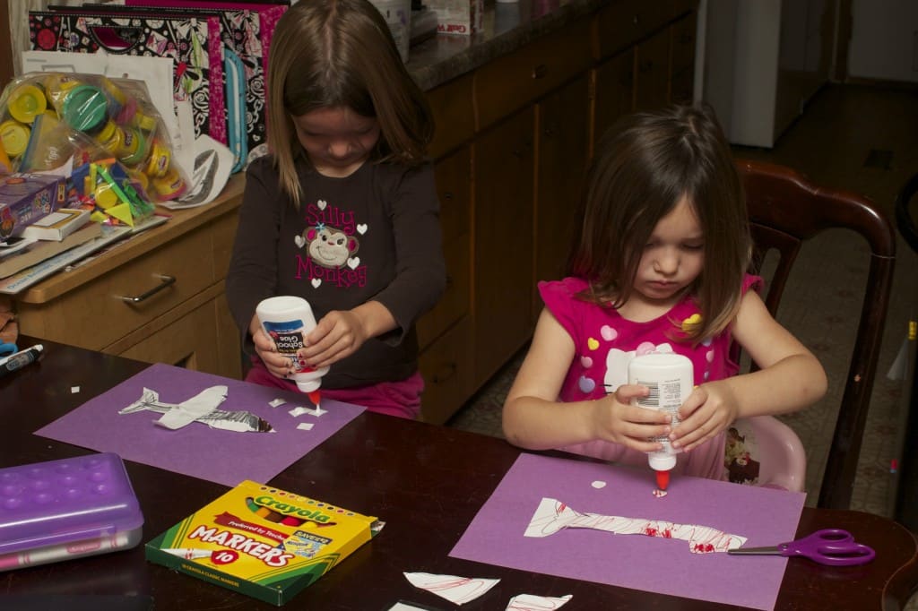 sisters crafting paper airplanes. 