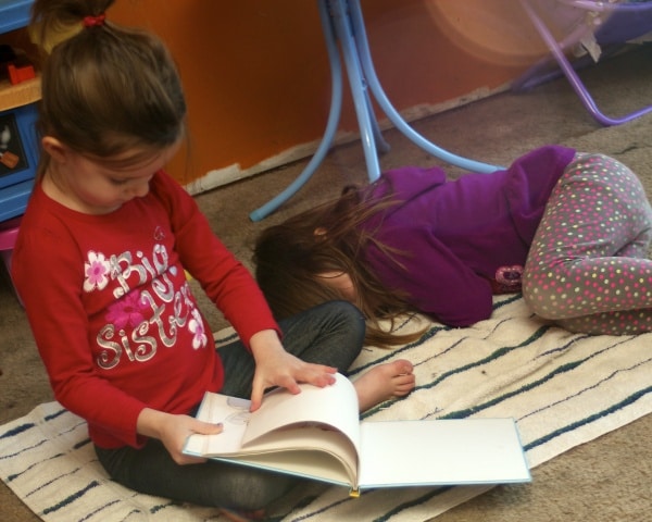 Big sister reading to her little sister