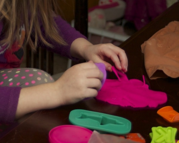 close-up of child playing with play doh