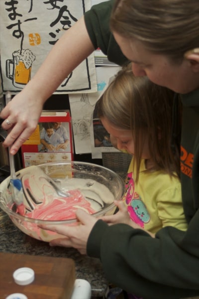 Mother and daughter mixing up a cake.