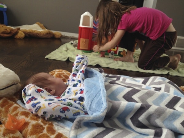 Baby watching girl play with toys