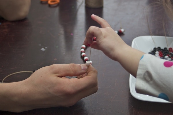 father and daughter making jewelry 