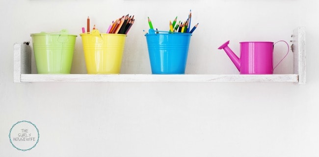 Shelf of homeschool supples on a white wall. 