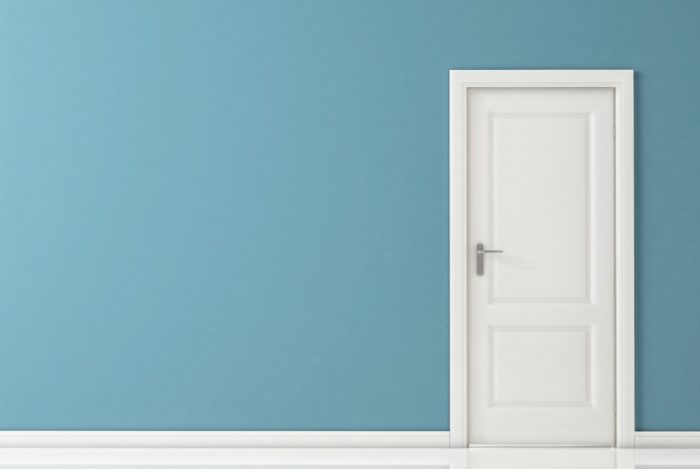 Simple blue wall with a white door. 