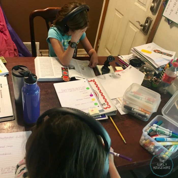 Homeschoolers doing school work at the kitchen table.