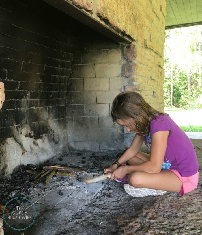 Young girl lighting a fire.