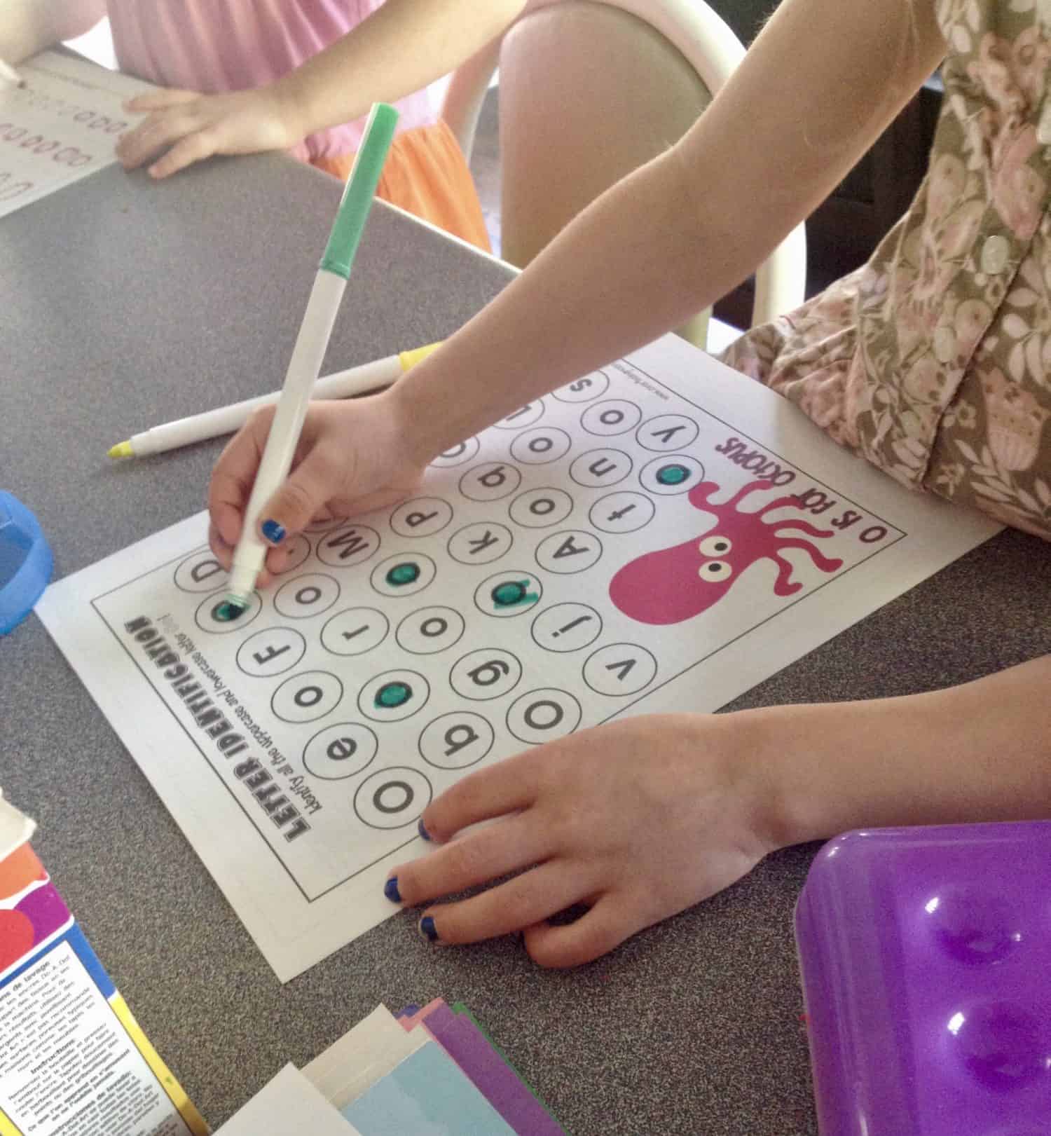 preschooler identifying the letter o on a worksheet.