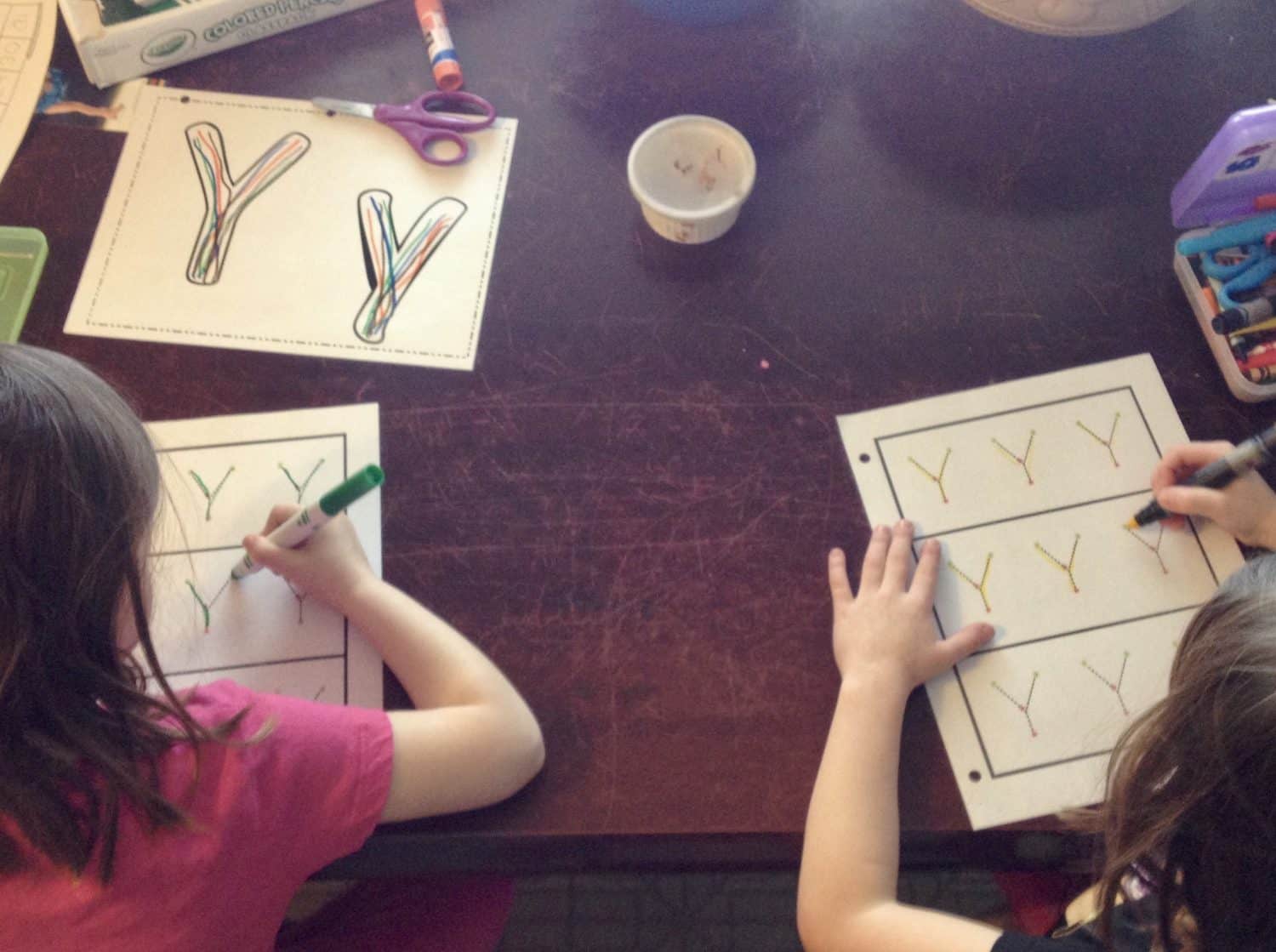 Homeschooled children working on writing the letter Y