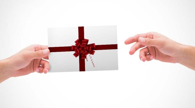 composite image of hands exchanging a gift envelope