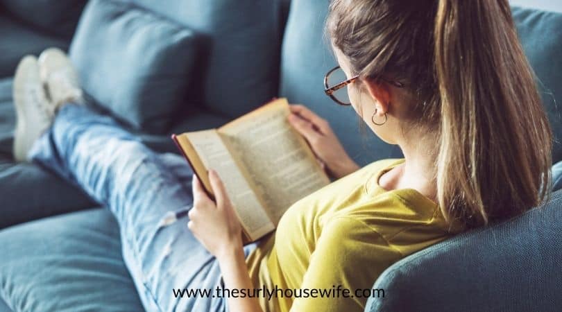 Young lady on the couch reading a book. Title image for blog post: YA books set in Alabama. 